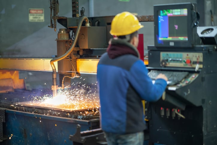 American engineer operating machinery in a metal manufacturing plant