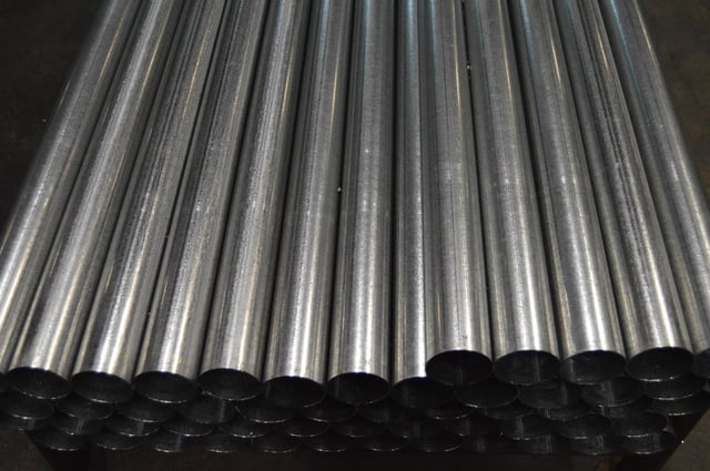 Stack of round metal tubing ready to be bent