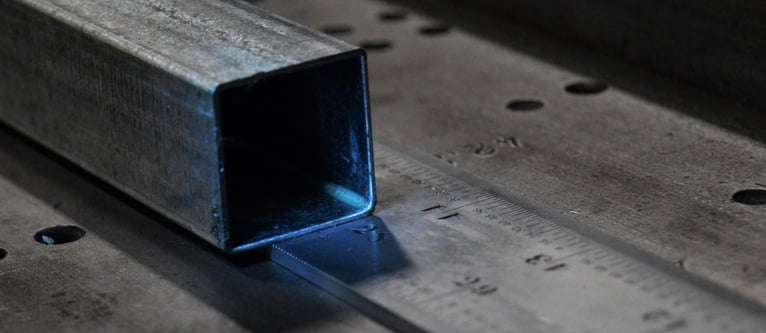 Square shaped steel tubing resting on a ruler