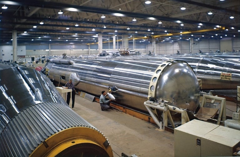 Engineers assemble a large cylindrical metal component