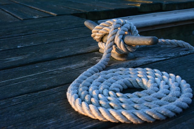 A coil of rope tied off to a dock cleat