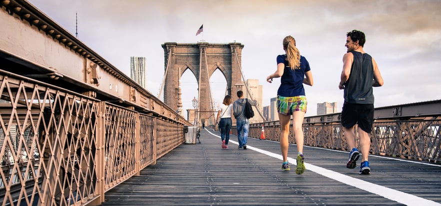 Joggers and pedestrians moving along the Brooklyn Bridge