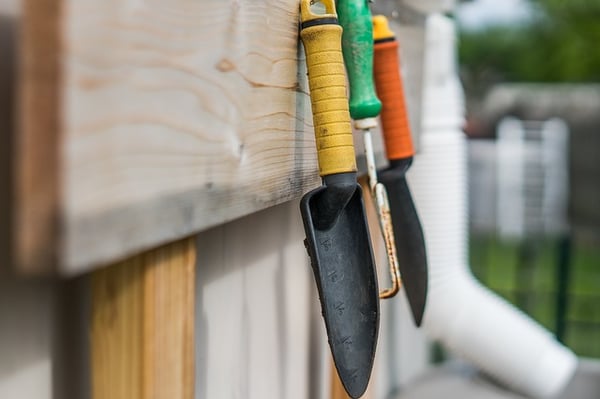 Garden tools hanging on a fence